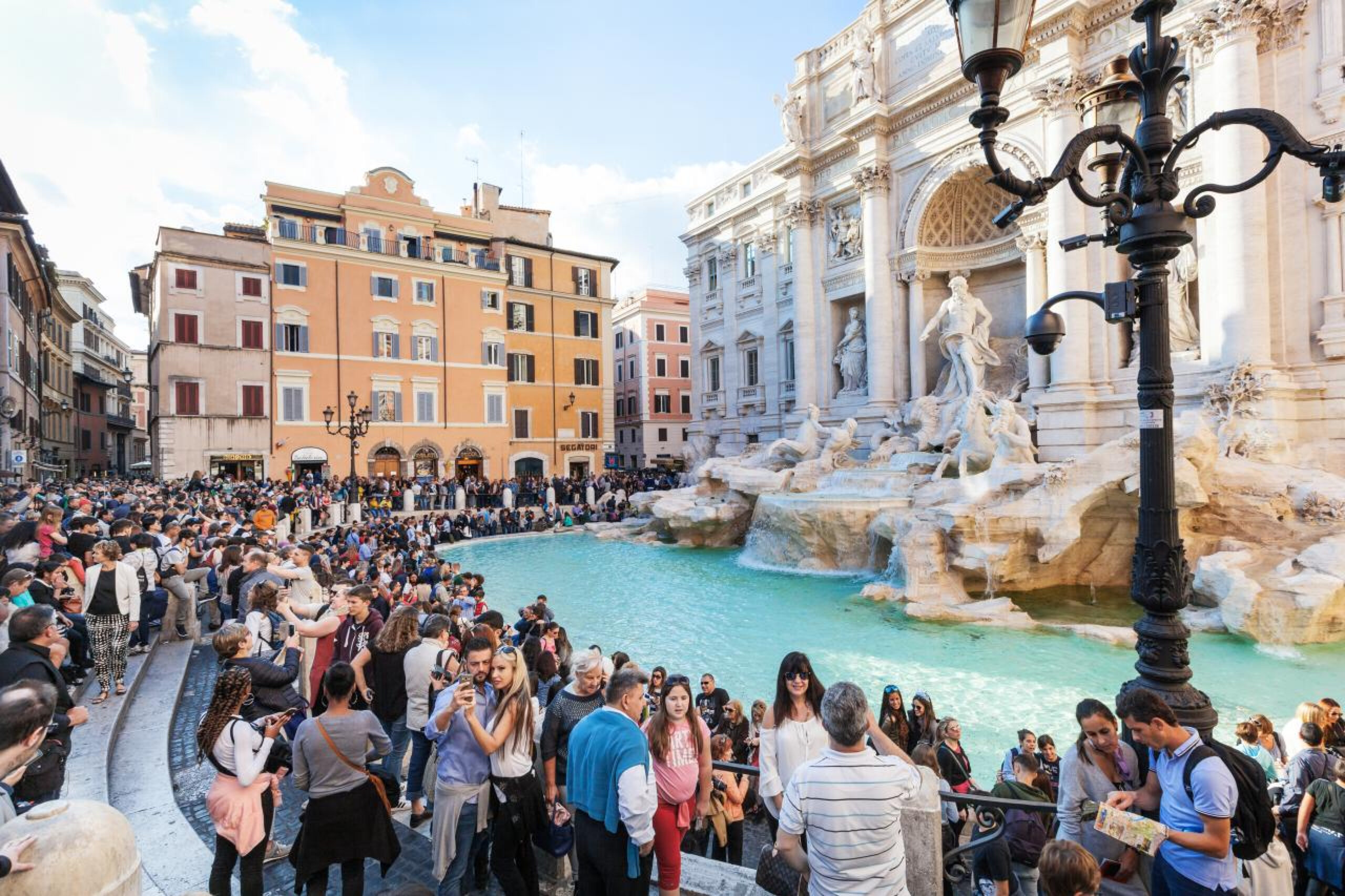Trevi Fountain Rome surrounded by visitors and historic architecture